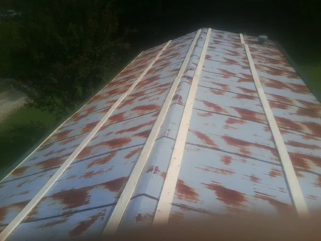 Rusted metal roof panels with new wood purlins before replacement — Storm Damage Roof Repair in Weldon by Roofing Brothers